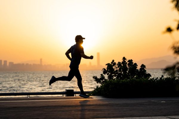 a man running on the beach at sunset